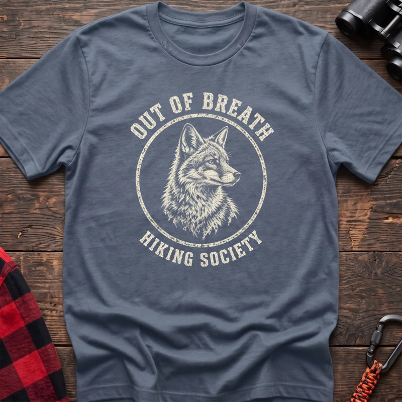 Stone blue cotton t-shirt with a wolf graphic and Out of Breath Hiking Society text on rustic wood