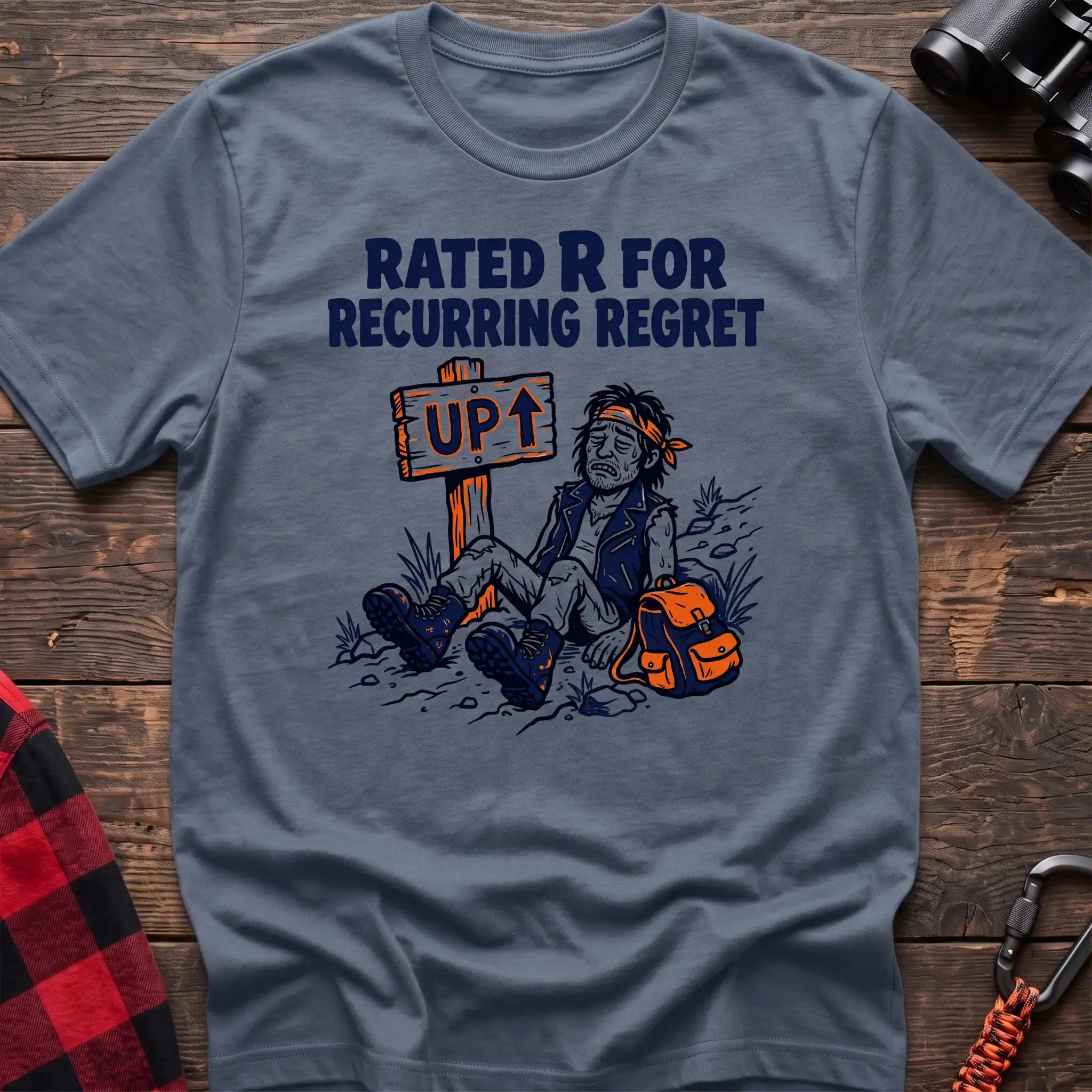 Stone blue t-shirt with illustration of an exhausted hiker sitting by an UP trail sign and the text Rated R for Recurring Regret