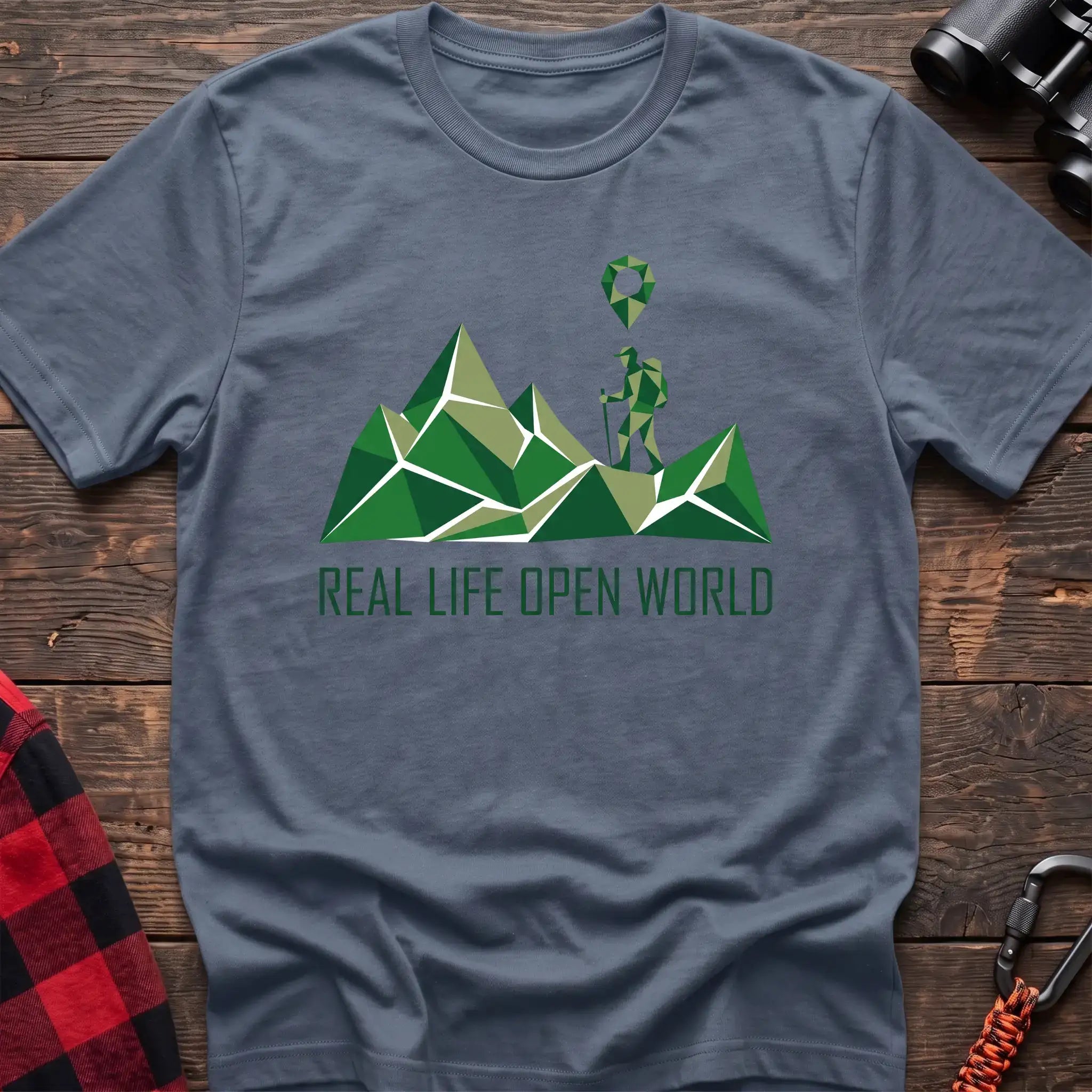 Stone blue t-shirt with geometric green mountain graphic and a hiker silhouette under a map pin, reading Real Life Open World