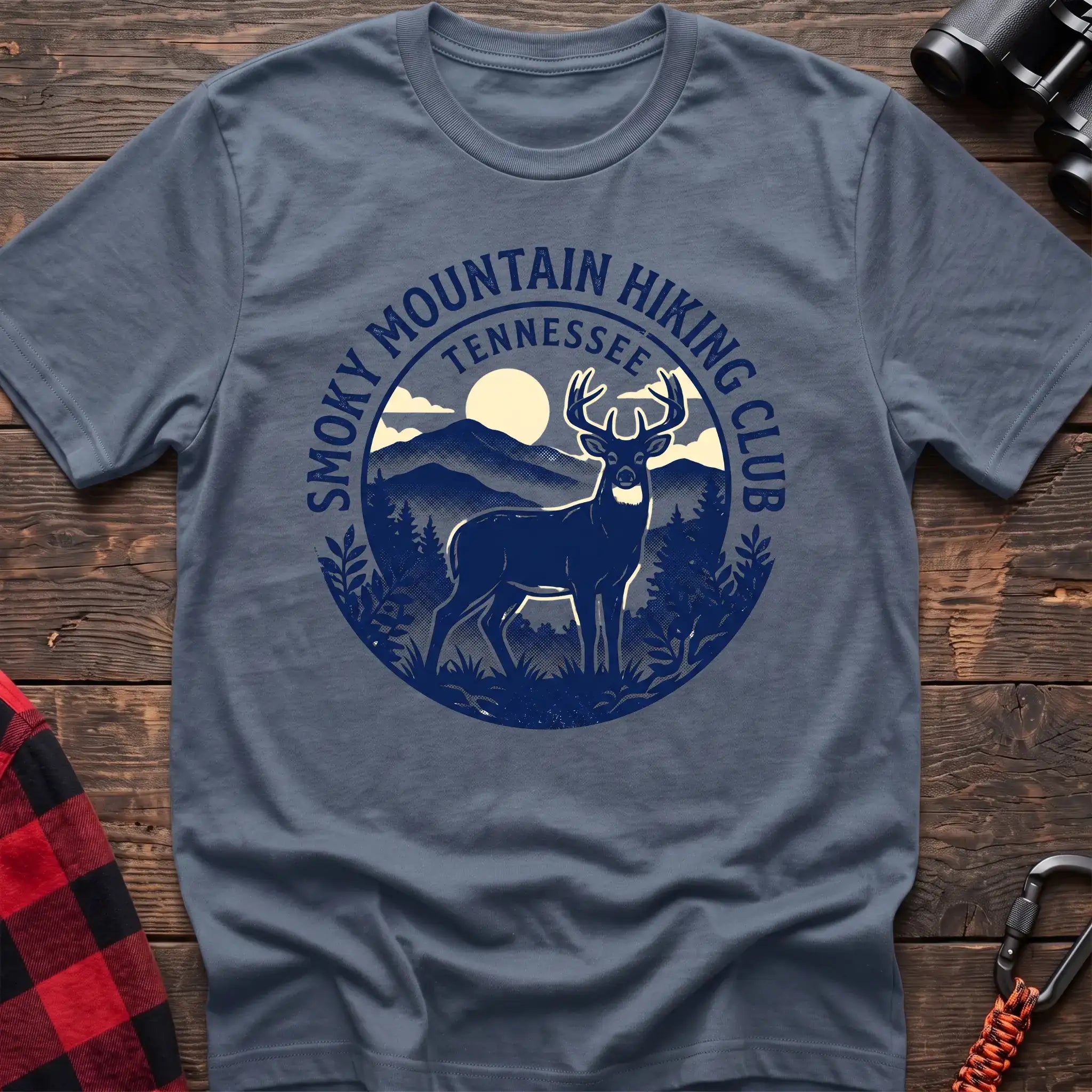 Stone blue t-shirt with circular badge graphic of a deer in the mountains reading Smoky Mountain Hiking Club Tennessee
