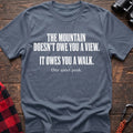Stone blue cotton t-shirt with The Mountain Doesn’t Owe You a View It Owes You a Walk text on rustic wood