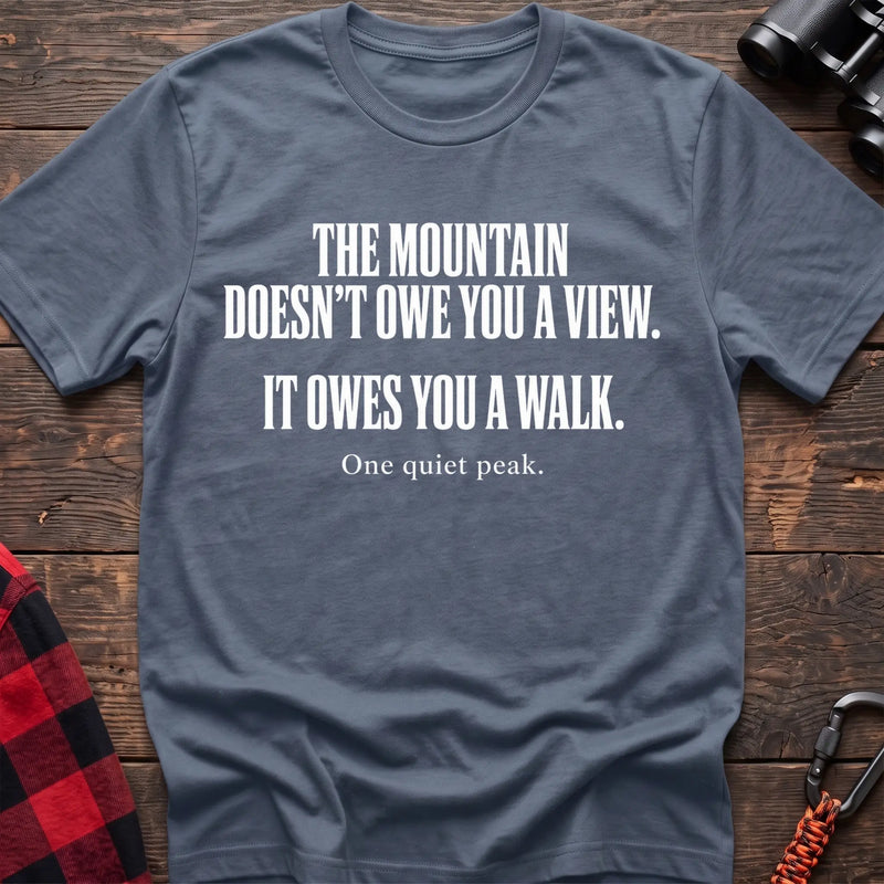 Stone blue cotton t-shirt with The Mountain Doesn’t Owe You a View It Owes You a Walk text on rustic wood