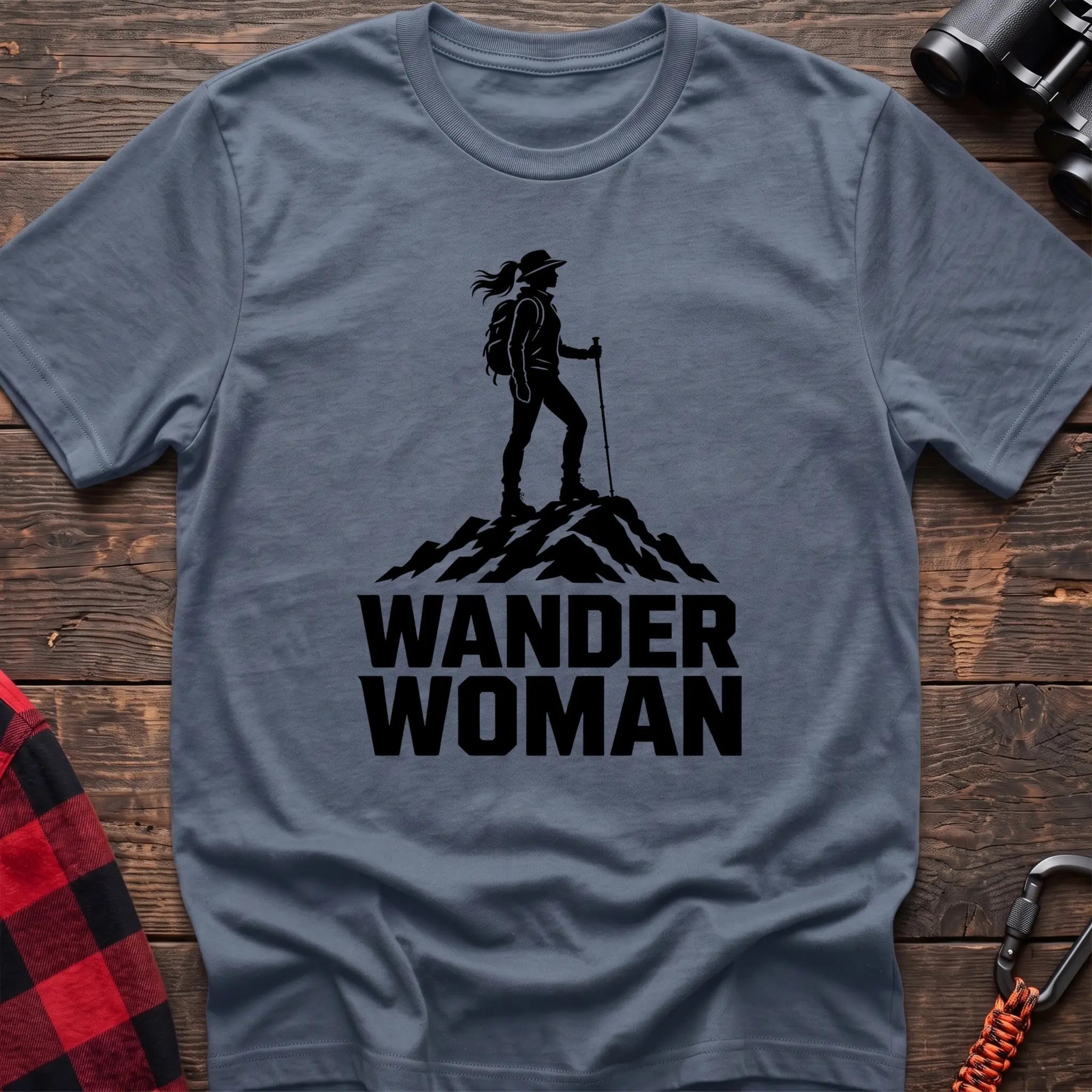 Stone blue cotton hiking t-shirt with black silhouette of a female hiker on a mountain peak and bold Wander Woman text