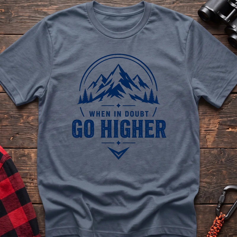 Stone blue cotton hiking t-shirt with navy mountain and pine tree graphic and "When in doubt go higher" quote