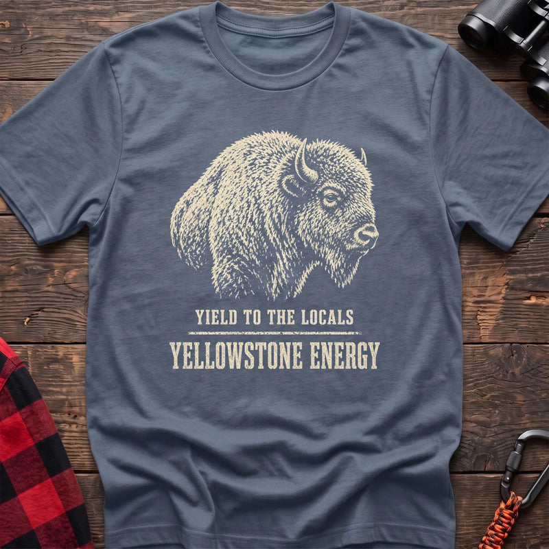 Stone blue cotton t-shirt with a bison graphic and Yield to the Locals Yellowstone Energy text on rustic wood