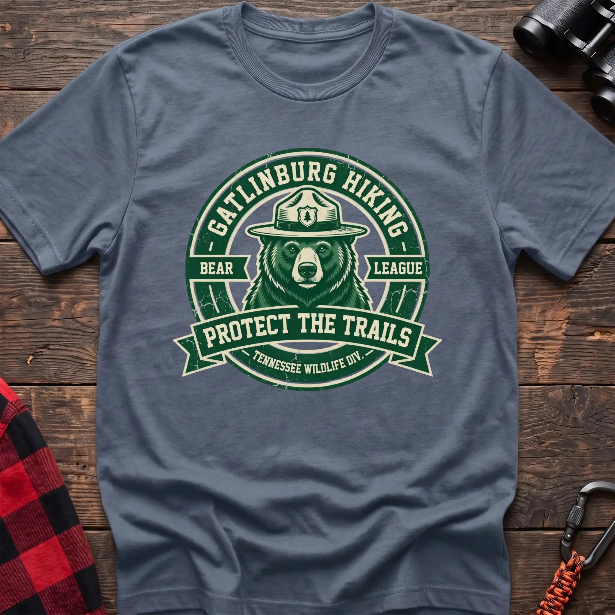 Stone blue t-shirt with circular badge of a bear in a ranger hat reading Gatlinburg Hiking Bear League Protect the Trails