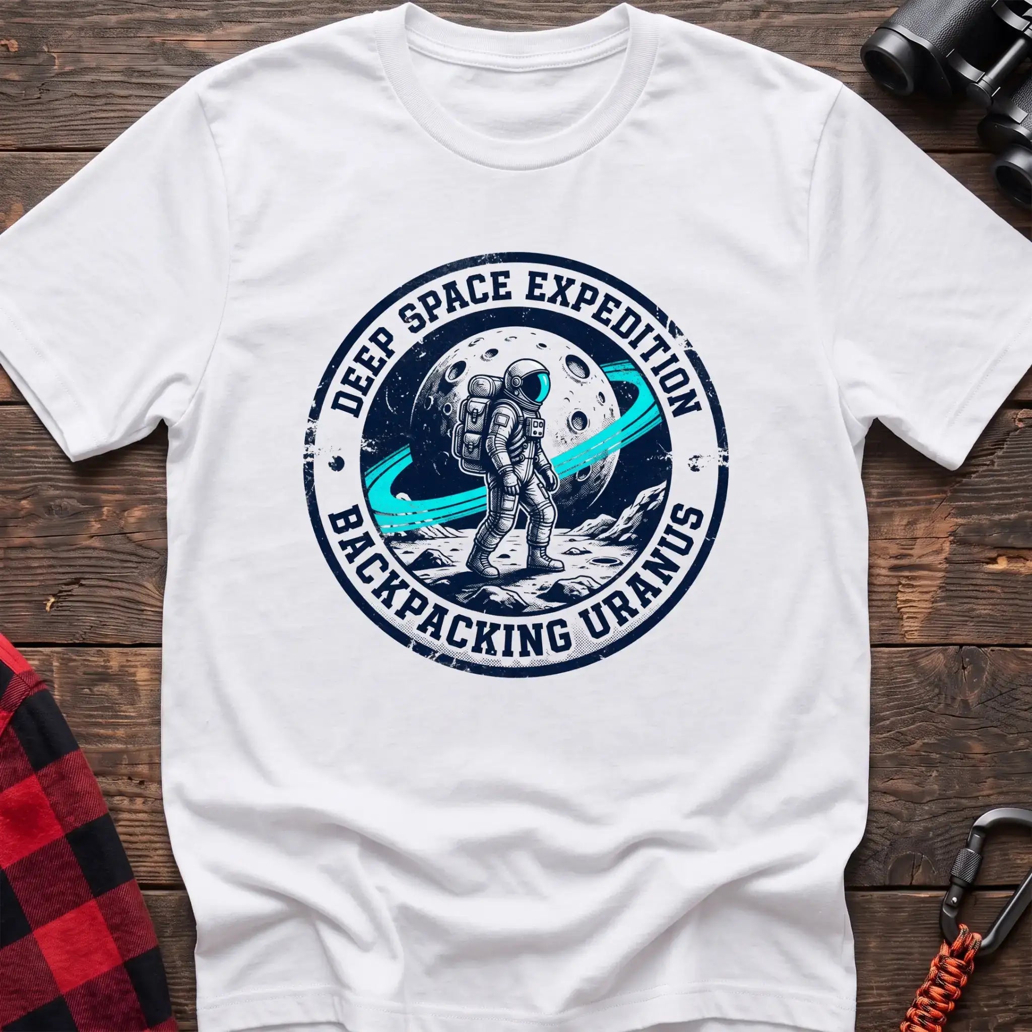 White t-shirt with circular badge graphic of an astronaut backpacking on Uranus, reading Deep Space Expedition Backpacking Uranus