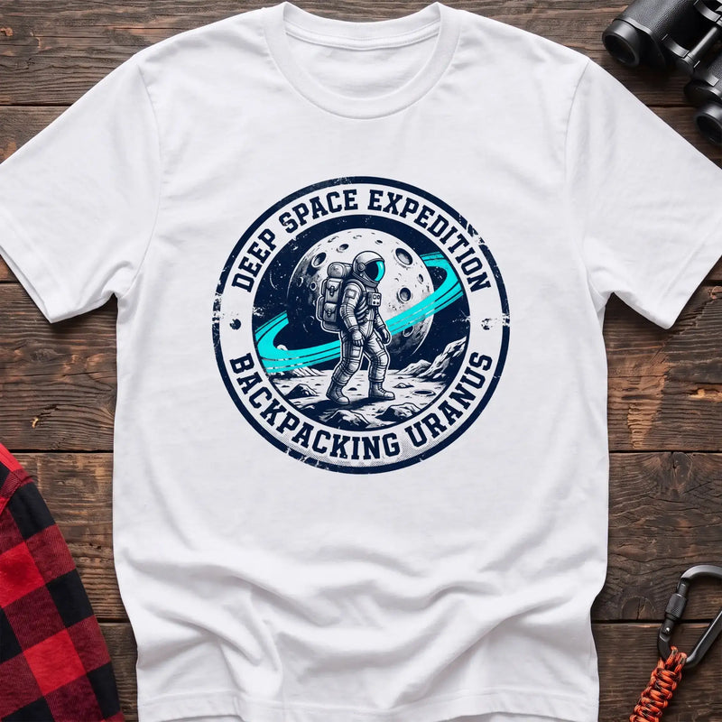 White t-shirt with circular badge graphic of an astronaut backpacking on Uranus, reading Deep Space Expedition Backpacking Uranus