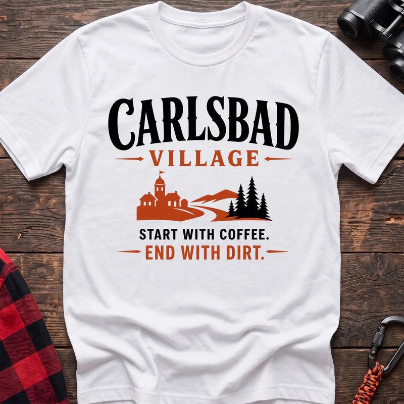 White cotton t-shirt with a village and trail graphic and Carlsbad Village Start with Coffee End with Dirt text on rustic wood