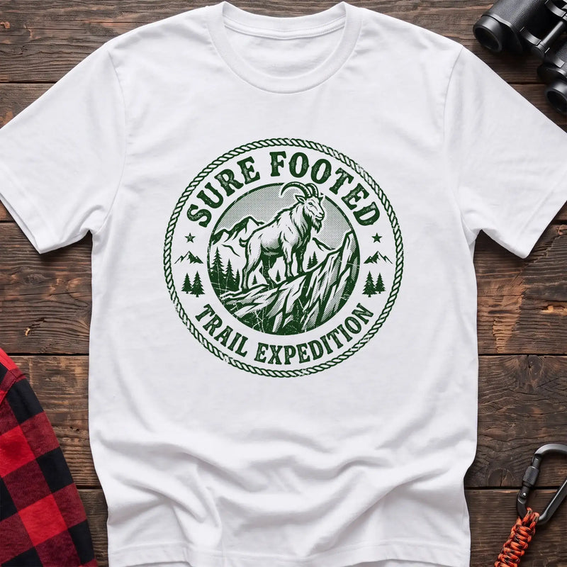 White t-shirt with circular badge graphic of a mountain goat on a rocky peak reading Sure Footed Trail Expedition