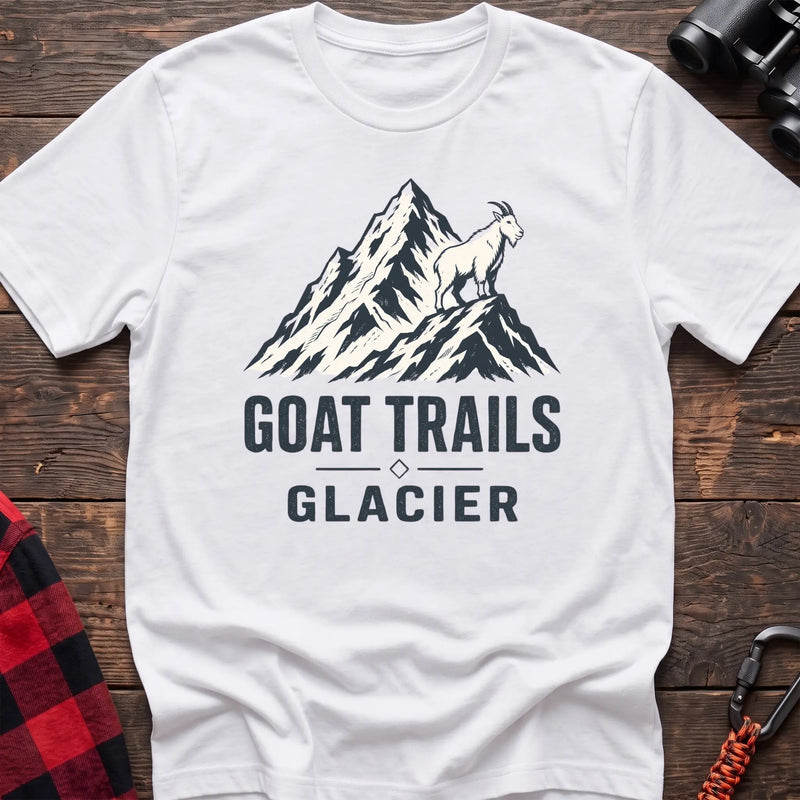 White cotton t-shirt with a mountain goat on a peak graphic and Goat Trails Glacier text on rustic wood