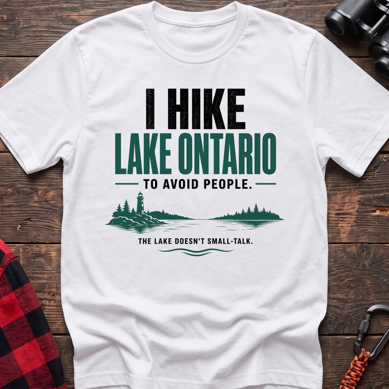 White cotton hiking t-shirt with lighthouse and lake graphic and "I hike Lake Ontario to avoid people – the lake doesn't small-talk" quote