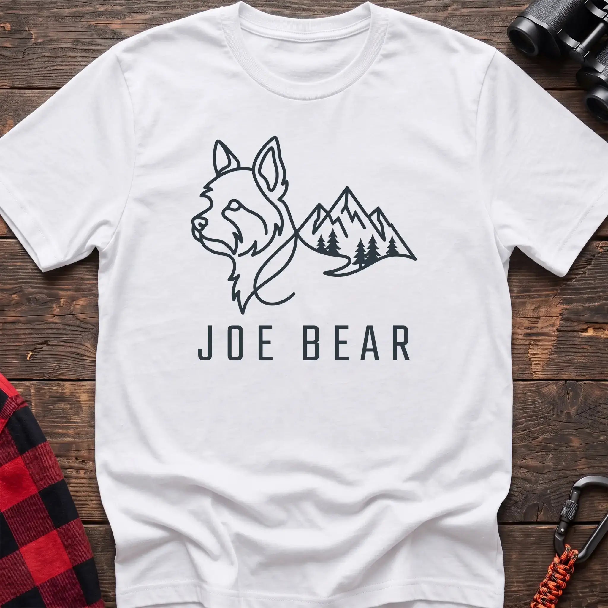 White t-shirt with dark line art of a yorkie dog head blending into mountains and pine trees, with the text Joe Bear