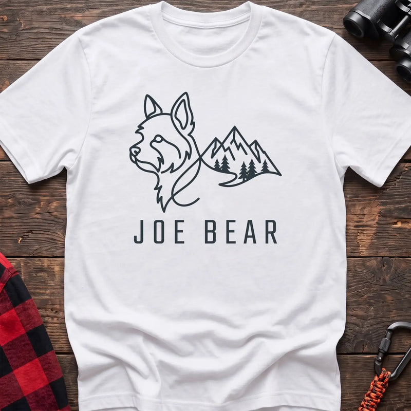 White t-shirt with dark line art of a yorkie dog head blending into mountains and pine trees, with the text Joe Bear