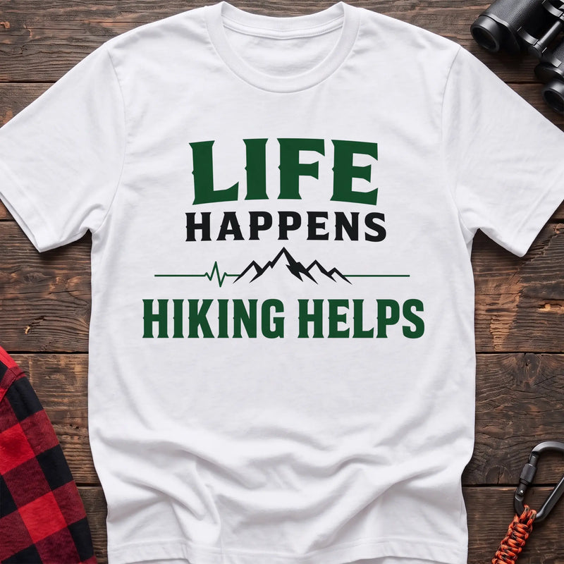 White cotton t-shirt with a mountain heartbeat graphic and Life Happens Hiking Helps text on rustic wood