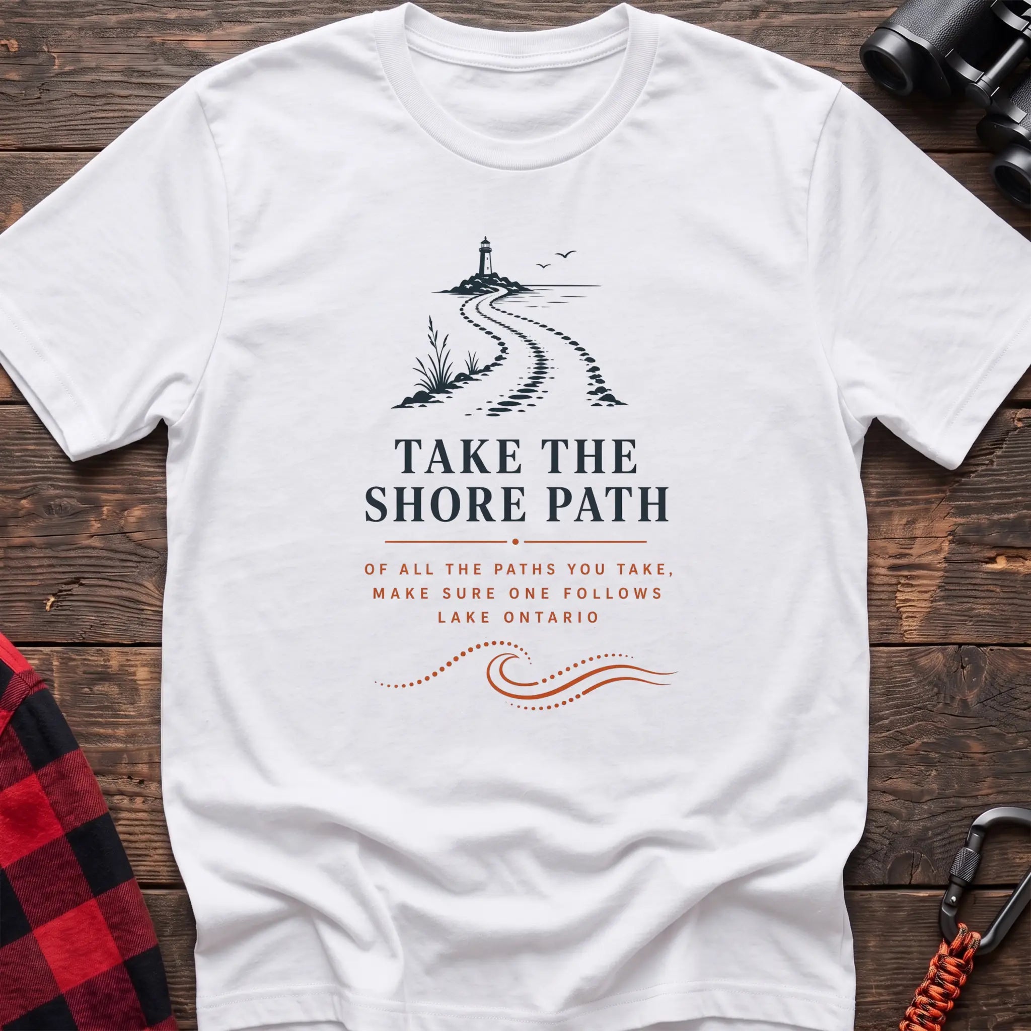 White cotton hiking t-shirt with lighthouse and winding shore path graphic and "Take the Shore Path – make sure one follows Lake Ontario" quote