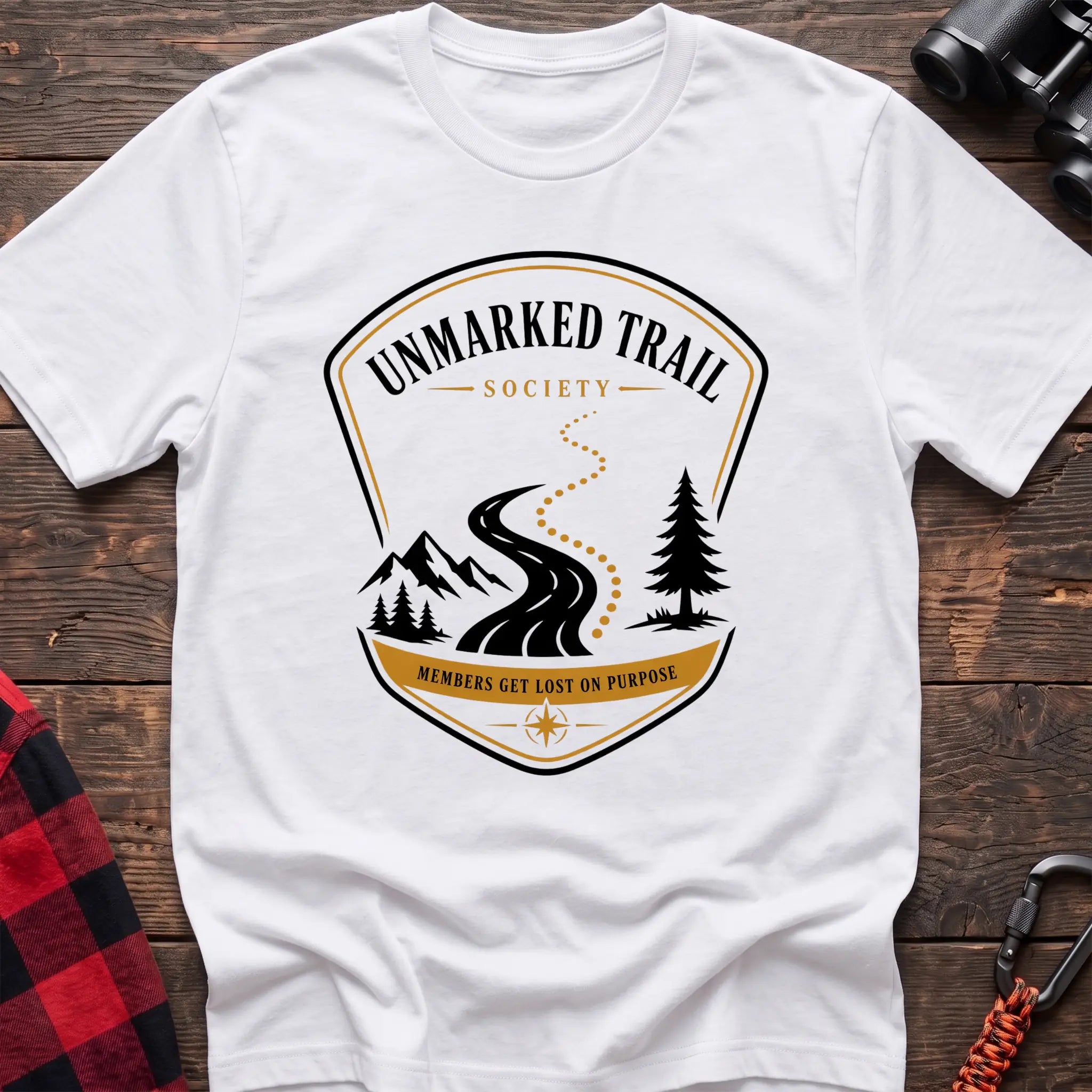 White cotton hiking t-shirt with Unmarked Trail Society badge, winding trail, mountains, pine trees, and "Members Get Lost on Purpose" text