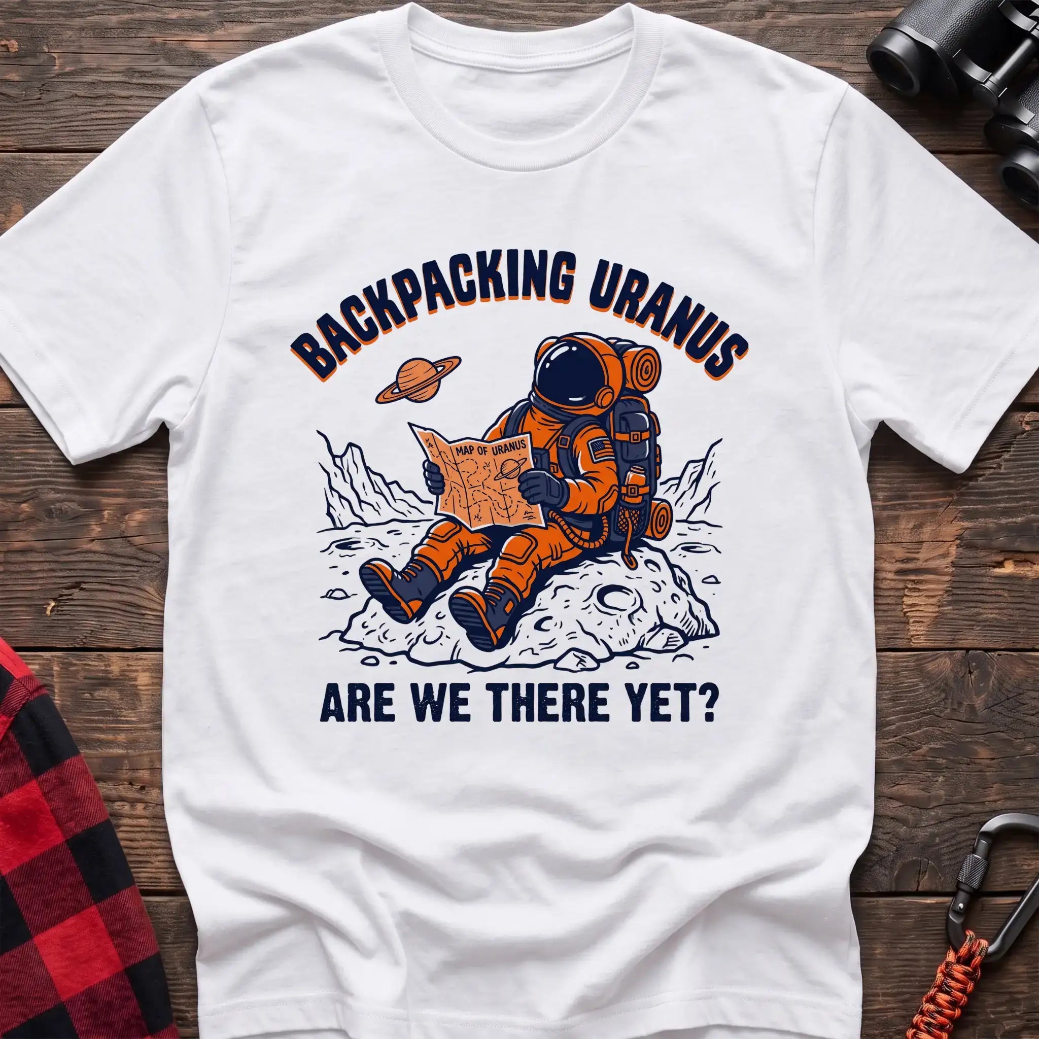 White t-shirt with astronaut sitting on a rock reading a Map of Uranus and the text Backpacking Uranus Are We There Yet