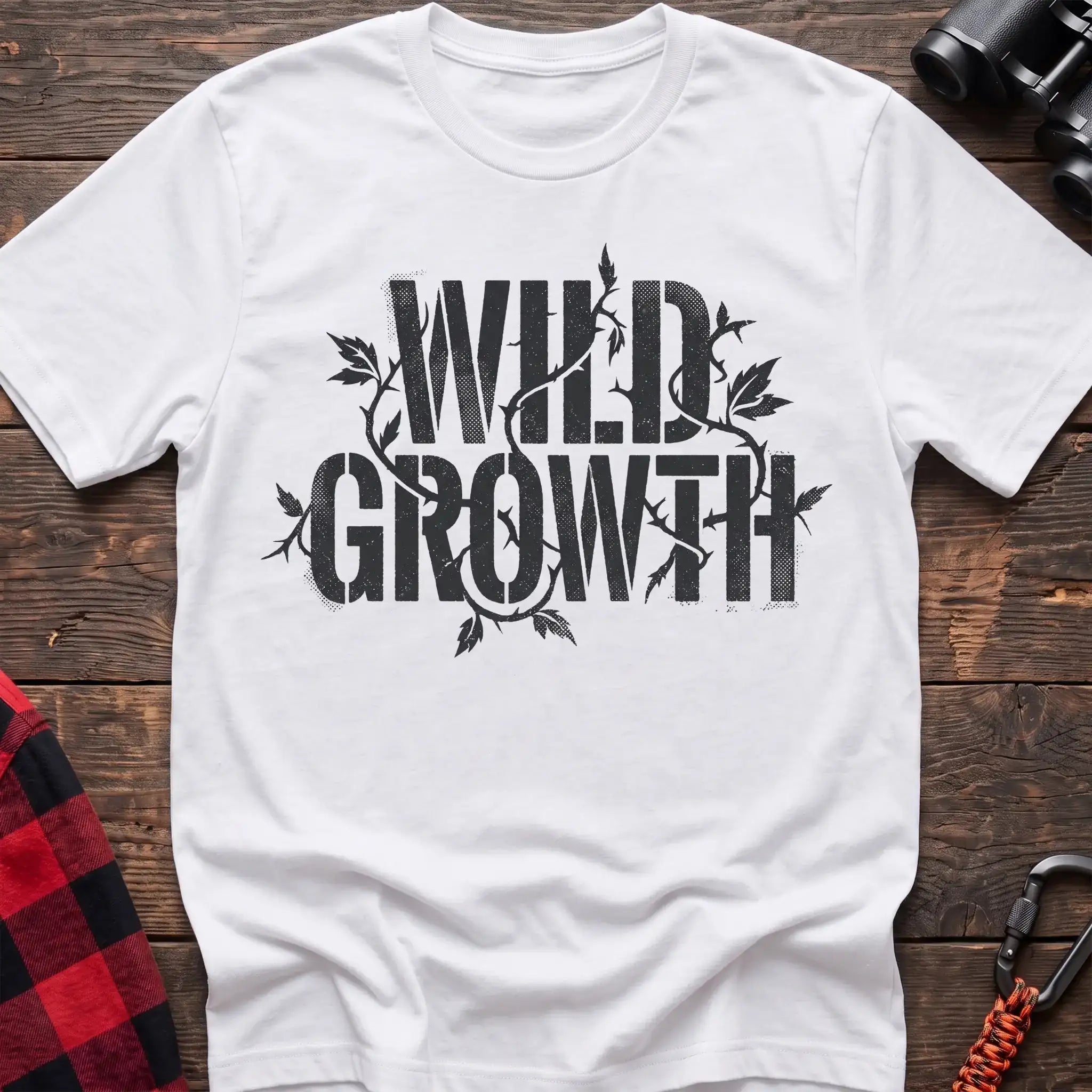 White t-shirt with dark text reading Wild Growth intertwined with thorny vines and leaves